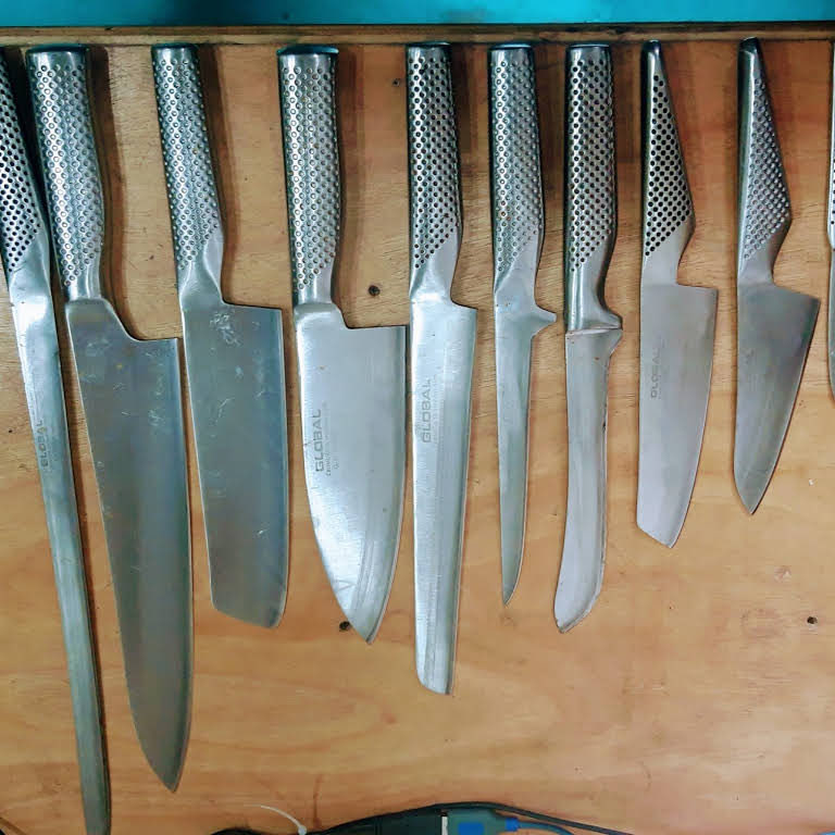 A row of kitchen knives on a magnetic rack